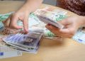 Person counting holiday currency-UK Pounds Sterling and Euros