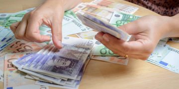 Person counting holiday currency-UK Pounds Sterling and Euros