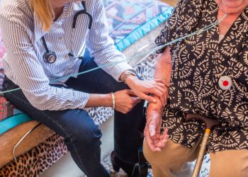 General practitioner on a home visit with an elderly patient.