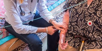 General practitioner on a home visit with an elderly patient.