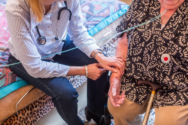 General practitioner on a home visit with an elderly patient.